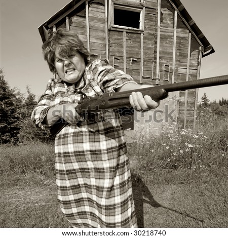 stock-photo-shotgun-momma-protects-her-moonshining-barn-with-a-rather-large-shotgun-30218740.jpg